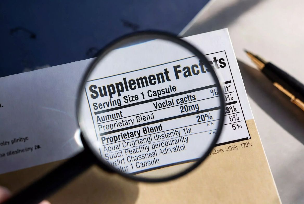 Supplement facts label with magnifying glass examining proprietary blend text — the dose transparency problem